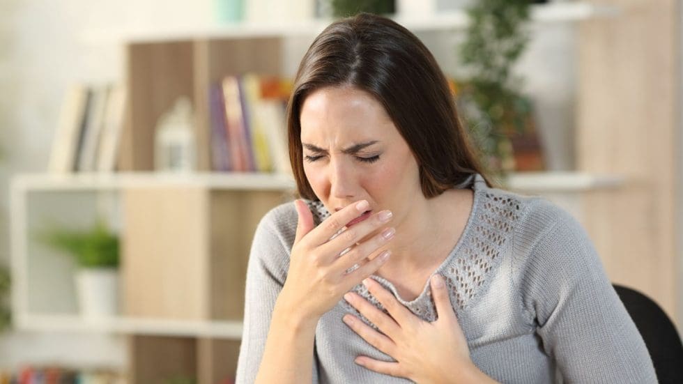 Woman Coughing And Holding Chest In Discomfort